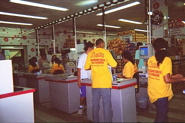 Photographie d'une rangée de caissières assises à leur poste dans un supermarché de São Paulo, au Brésil.