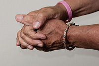 hands with cancer bracelet